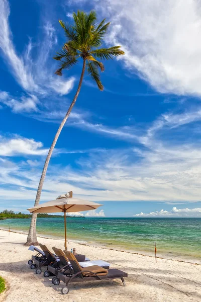 Strandstolar med handdukar under paraply vid stranden av jag — Stockfoto