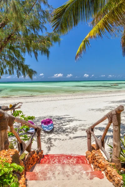 Weg zum weißen Sandstrand mit Booten unter Palmen Stockbild