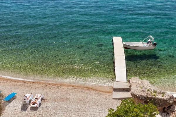 View to Glyfa beach with tourist on lounge chairs and swimming — Stock Photo, Image