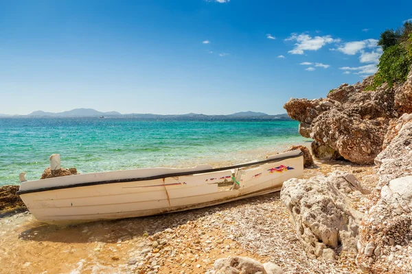 Destinado barco de pesca en las rocas bajo la luz del sol brillante — Foto de Stock