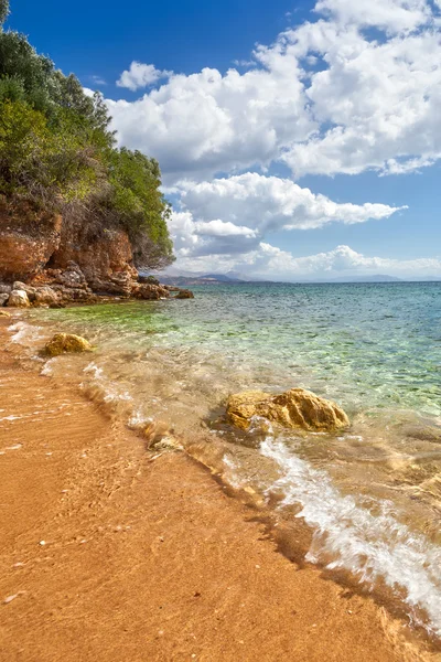 Vista a la ola sobre guijarros y rocas en la arena — Foto de Stock