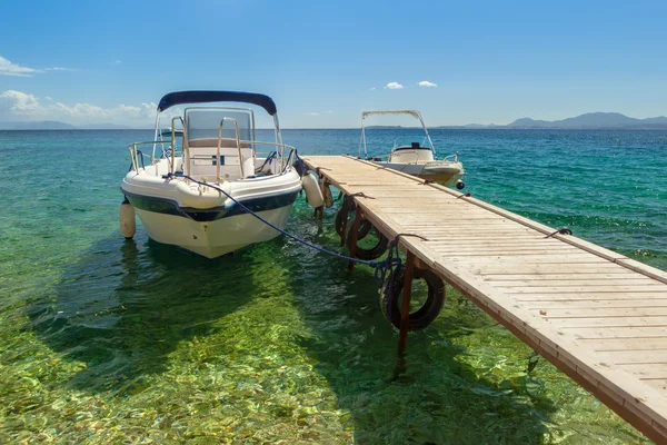 Barco vacío de pie en el muelle de madera bajo la luz del sol — Foto de Stock