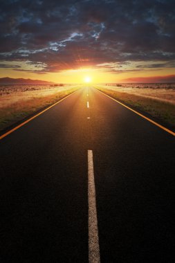 Straight asphalt road leading into sunlight clipart