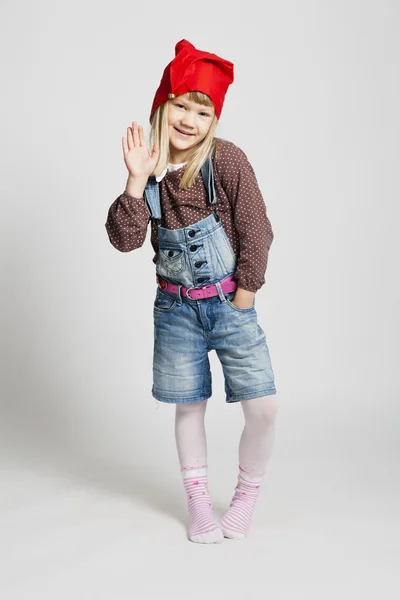 Smiling girl wearing Christmas hat and waving — Stock Photo, Image