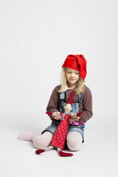 Ragazza sorridente che tiene bambola elfo di Natale — Foto Stock