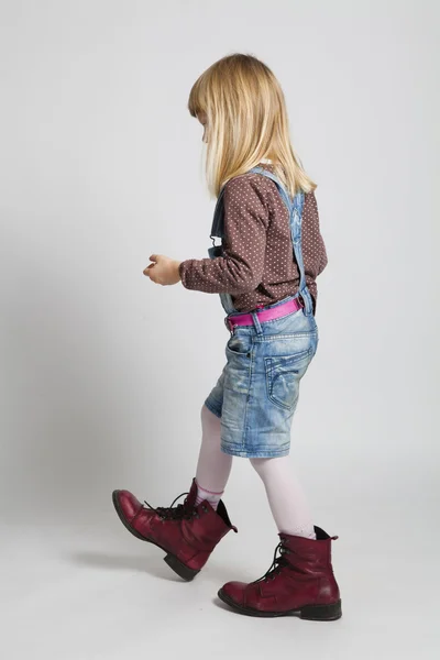 Young girl walking in adult sized boots — Stock Photo, Image