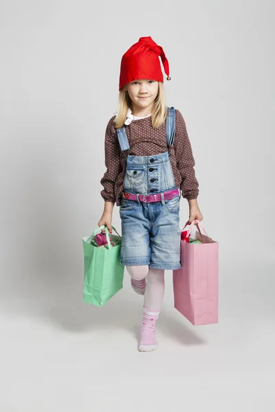 クリスマスの買い物袋を運ぶ幸せな若い女の子 — ストック写真