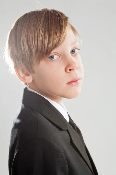 Sérieux jeune garçon en costume noir — Photo