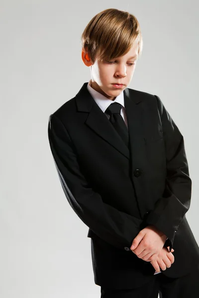 Serious young boy wearing black suit — Stock Photo, Image