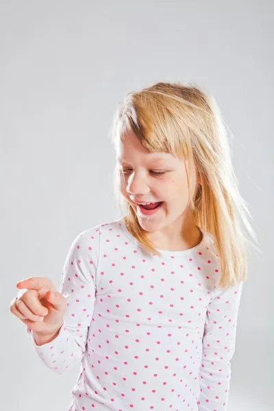 Glücklich lächelndes junges Mädchen zeigt — Stockfoto