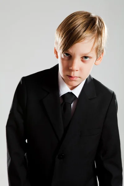 Grave menino vestindo terno preto — Fotografia de Stock