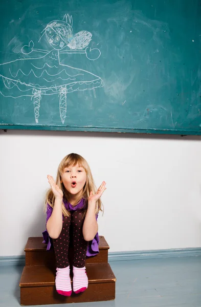 Young girl blowing kiss in classroom — Stock Photo, Image