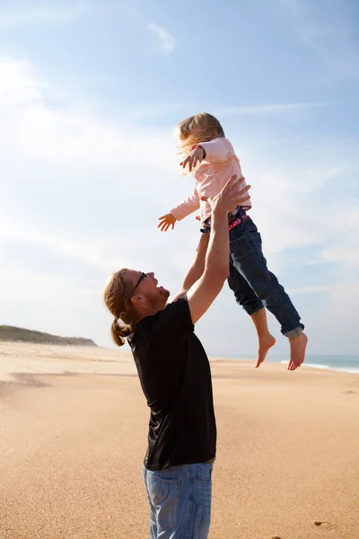 Apa lánya dobott a levegőben, a strandon — Stock Fotó