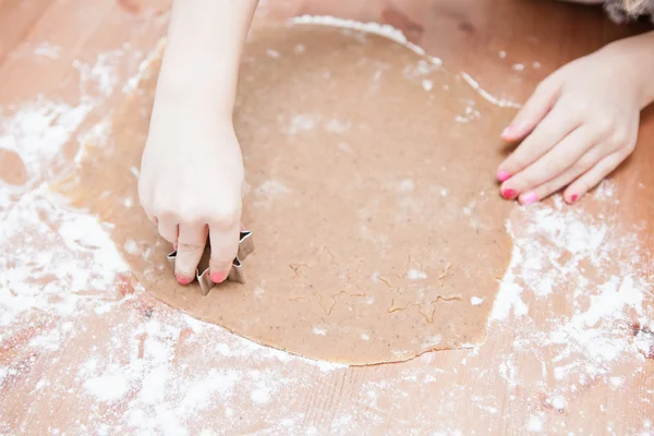 Cutting gingerbread shapes from dough — Stock Photo, Image