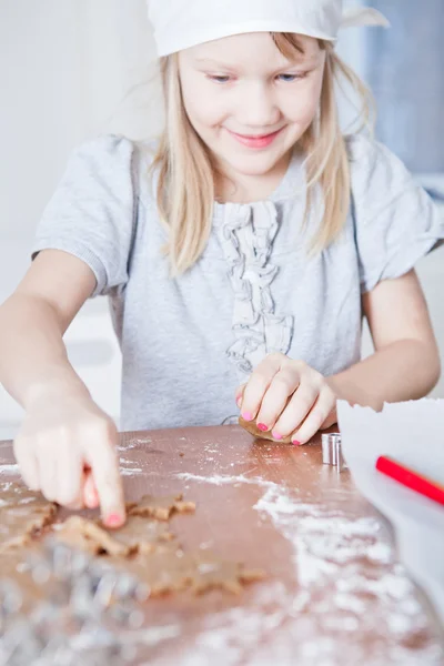 Giovane ragazza che punta alla forma di pan di zenzero — Foto Stock