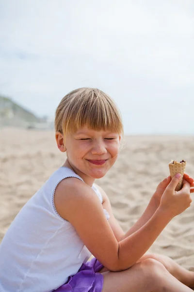 Menina feliz com sorvete na praia — Fotografia de Stock