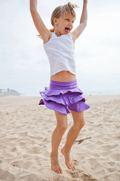 Young girl jumping in sand — Stock Photo, Image