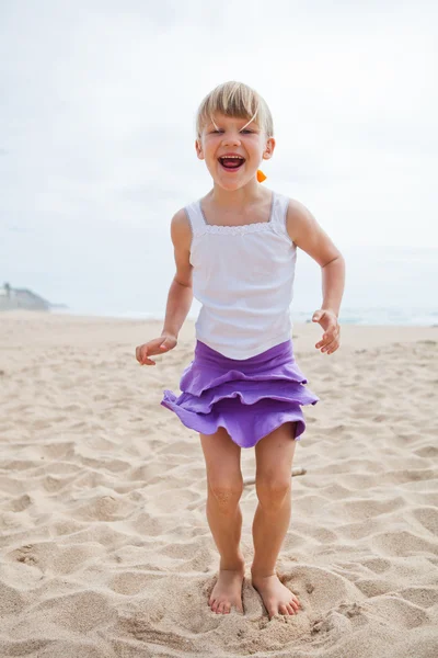 Chica joven jugando en la playa — Foto de Stock