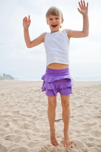 Young girl jumping in sand — Stock Photo, Image