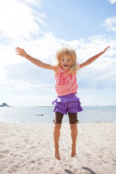 Young girl jumping at beach — Stock Photo, Image