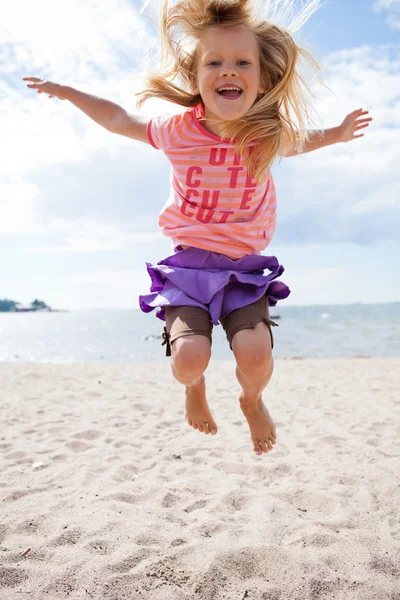 Young girl jumping at beach — Stock Photo, Image