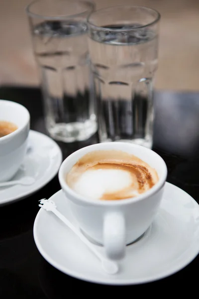 Twee kopjes koffie en water — Stockfoto