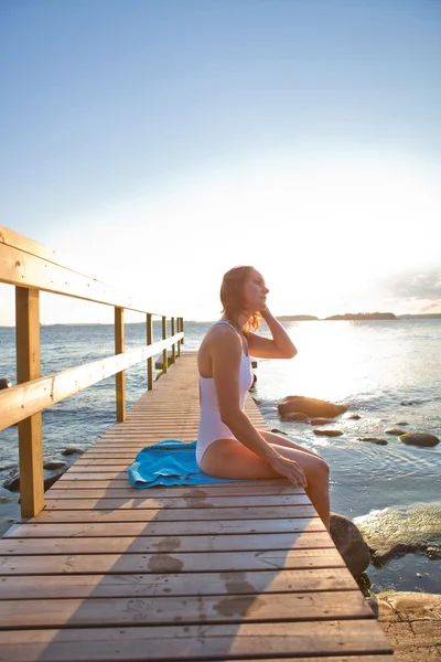 Attractive woman sitting on pier — Stock Photo, Image