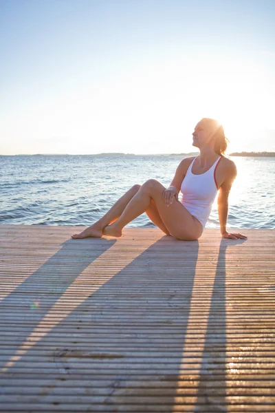 Attractive woman sitting on pier — Stock Photo, Image