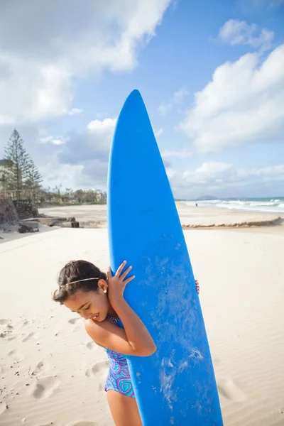 Gelukkig jong meisje met surfboard op strand — Stockfoto