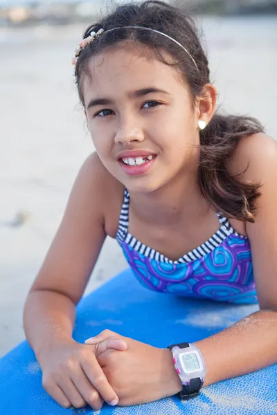 Cute young girl lying on surfboard — Stock Photo, Image