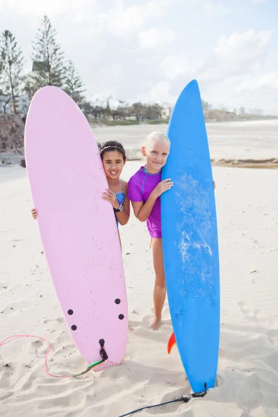 Két boldog fiatal lányok holding szörfdeszkák strandon — Stock Fotó