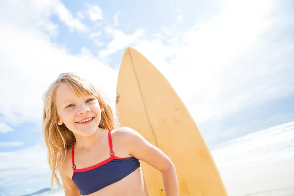 Menina feliz com prancha de surf na praia — Fotografia de Stock