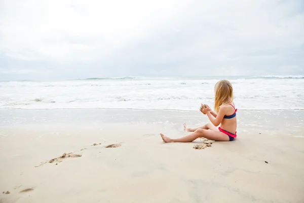 Chica joven jugando en la playa — Foto de Stock