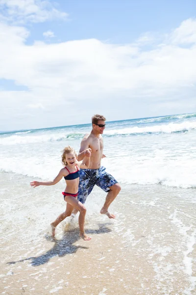 Glücklicher Vater und Tochter laufen im flachen Wasser am Strand entlang — Stockfoto