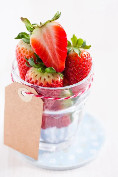 Fresh strawberries in glass with tag — Stock Photo, Image