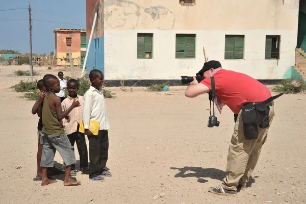 Fotoperiodista lleva a chicos somalíes fuera de Berbera . — Foto de Stock