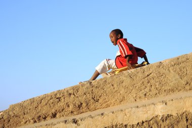 Somali boys are riding on the hill of concrete clipart