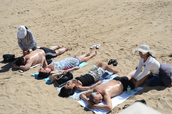 Masseuse doen de massage op het strand — Stockfoto