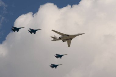 MOSCOW, RUSSIA-MAY 7, 2021: Bir grup SU-35S savaşçısı ve bir Tu-160 süpersonik uzun menzilli stratejik bombardıman uçağı geçit töreninin kostümlü provası sırasında Moskova 'nın Kızıl Meydanı üzerinde uçuyor.
