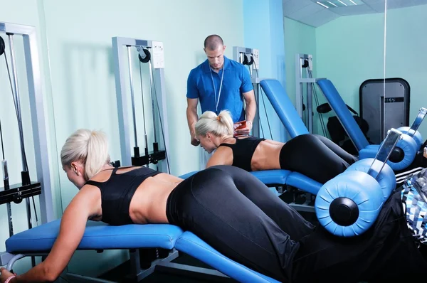 Mujer en ejercicio de gimnasio con entrenador de fitness personal — Foto de Stock