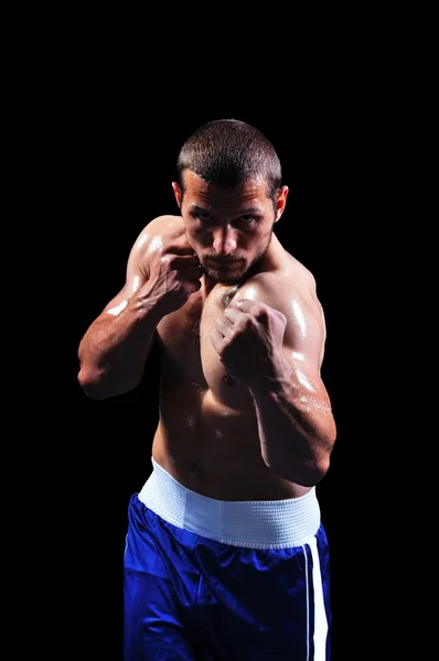 Krachtige gespierde bokser die zich voordeed op zwarte achtergrond — Stockfoto