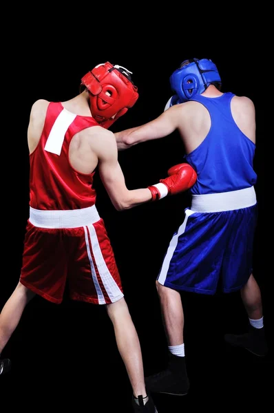 Dos boxeadores masculinos peleando sobre fondo negro — Foto de Stock