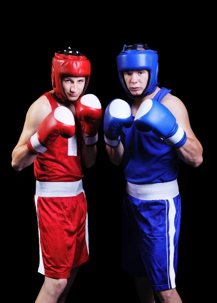 Dos boxeadores masculinos peleando sobre fondo negro — Foto de Stock
