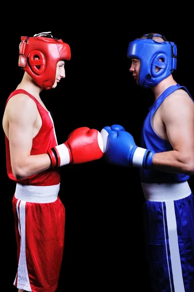 Dos boxeadores masculinos peleando sobre fondo negro — Foto de Stock