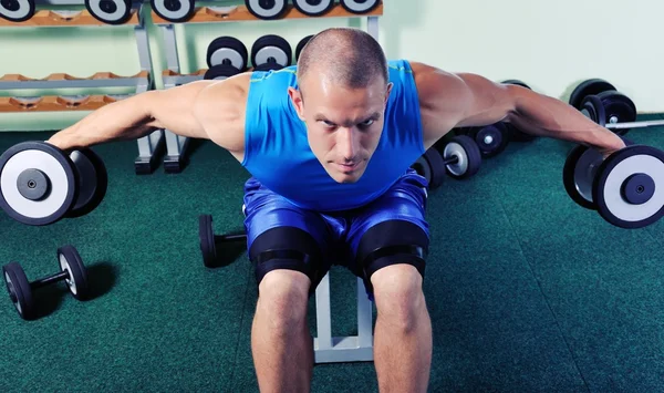 Uomo muscolare che esercita in una palestra — Foto Stock