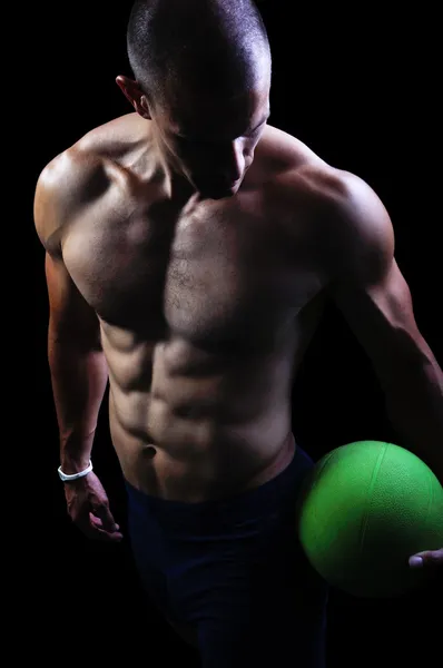 Muscular athlete man exercise on a black background — Stock Photo, Image