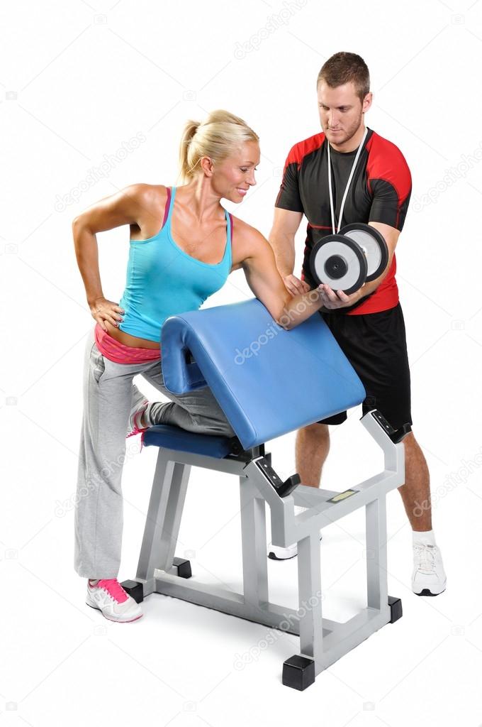 Beautiful woman exercising with personal fitness trainer on a wh