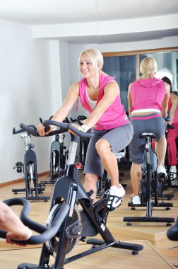 güzel kadınlar bir spinning dersi spor salonunda egzersiz yapıyor