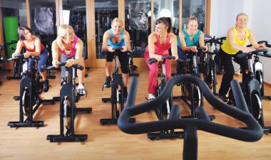 güzel kadınlar bir spinning dersi spor salonunda egzersiz yapıyor