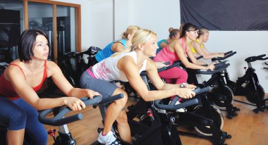 güzel kadınlar bir spinning dersi spor salonunda egzersiz yapıyor